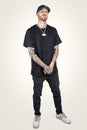 Tattooed rap singer posing in studio wearing black clothes Royalty Free Stock Photo