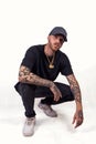 Tattooed rap singer posing in studio wearing black clothes Royalty Free Stock Photo