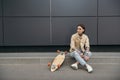 tattooed stylish woman sitting near skateboard