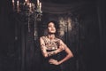 Tattooed woman in spooky interior