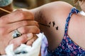 Tattooist Making a Temporary Tattoo on the Shoulder of a Young G