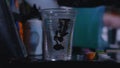 A tattooist mixing ink in a cup of water in a tattoo studio in slow motion