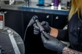 A tattooist woman carefully prepares her tattoo machine in her studio