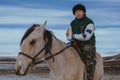 TAU SAMALY, KAZAKHSTAN - DECEMBER 23, 2023: Kazakh woman riding a horse in winter in field near Tau Samaly in Kazakhstan