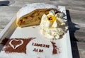 TAUERN ALM, ITALY - SEPTEMBER 4, 2023: Delicious strudel with apples, nuts and powdered sugar on the table