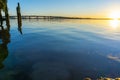 Tauranga Harbour Bridge arches across the harbour in distance back-lit by golden sunrise glow