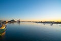 Tauranga harbour at sunrise with port facilities and landmark Mount Maunganui on golden horizon