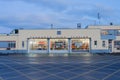 Deco style fire station at twilight with interior illuminated through doors