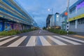 Leading lines of pedestrian crossing in foreground to street lined with commercial buildings