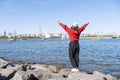 Taveler girl wear hat red sweater raise arms turn back at Daiba beach famous landmark at Japan