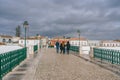 The Roman bridge in Tavira, Portugal, with white railings and stone arches, crossing over a calm river Royalty Free Stock Photo