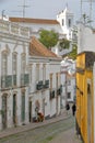 Typical facades along a steep cobbled street with Santa Maria do Castelo Church in the background