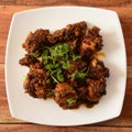 Tawa mutton fry or tawa gosht is authentic spicy lamb dish.Cooked with spices,served over a rustic wooden background, selective