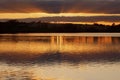 Tawny sunset reflected across a shimmering Ravensthorpe Reservoir, Ravensthorpe, Northamptonshire