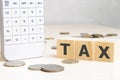 Tax Concept with wooden block on stacked coins Royalty Free Stock Photo