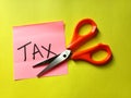 Tax cut bill and scissors on yellow background