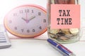 TAX DAY CONCEPT; Clock,red note,calculator and coins in the mason jar over wooden background. Royalty Free Stock Photo