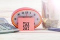 TAX DAY CONCEPT; Clock,red note,calculator and coins in the mason jar over wooden background. Royalty Free Stock Photo