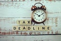 Tax Deadline with alarm clock with space copy on wooden background