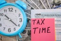 Tax form 1040, alarm clocks dollars on a wooden table. Close-up. Business concept.