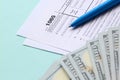 1065 tax form lies near hundred dollar bills and blue pen on a light blue background. US Return for parentship income Royalty Free Stock Photo