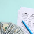 1065 tax form lies near hundred dollar bills and blue pen on a light blue background. US Return for parentship income Royalty Free Stock Photo