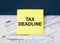 Tax form 1065 with yellow sticker with text Tax Deadline. Notepad and white pen