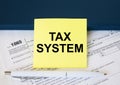 Tax form 1065 with yellow sticker with text Tax System. Notepad and white pen