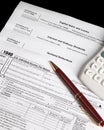 Tax forms with calculator and pen