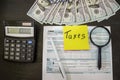 Tax forms 1040 with dollars, sticker, pen and calculator on a black wood table. Tax time concept. Financial document. Royalty Free Stock Photo