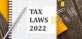 TAX LAWS 2022 text on a sticker on the notebook, wooden background Royalty Free Stock Photo