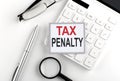 TAX PENALTY text on the sticker with calculator, glasses and magnifier Royalty Free Stock Photo