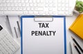 TAX PENALTY written on the paper with keyboard, chart, calculator and notebook Royalty Free Stock Photo