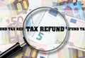 Tax Refund , View through a magnifying glass on the inscription on the background of Euro Banknotes. Business Finance.