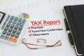 Tax report on a desk with tick against premises, found non-conformities and observations