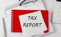TAX REPORT word on the sticker on notepad with pen and calculator Royalty Free Stock Photo