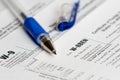 Tax reporting forms with opened blue pen Royalty Free Stock Photo