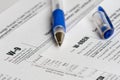 Tax reporting forms with opened blue pen Royalty Free Stock Photo