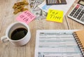 tax return form 1040, visible cup of coffee, pen, calculator . Tax, accounting, business, finance and office concepts.