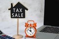 Tax sale text on wooden house model with on white table. Property tax concept. Royalty Free Stock Photo