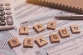 Tax season with wooden alphabet blocks, calculator, pen on 1040 tax form background Royalty Free Stock Photo