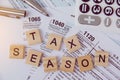 Tax season with wooden alphabet blocks, calculator, pen on 1040 tax form background