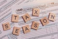 Tax season with wooden alphabet blocks, calculator, pen on 1040 tax form background Royalty Free Stock Photo