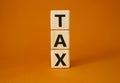 Tax symbol. Wooden cubes with word Tax. Beautiful orange background. Business and Finace and Tax concept. Copy space