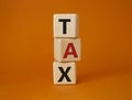 Tax symbol. Wooden cubes with word Tax. Beautiful orange background. Business and Finace and Tax concept. Copy space