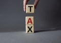 Tax symbol. Wooden cubes with word Tax. Businessman hand. Beautiful grey background. Business and Finace and Tax concept. Copy