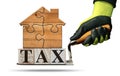 Tax Text made of Wooden Blocks on a Trowel with a Wooden House Royalty Free Stock Photo