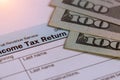 Tax time Closeup of U.S. 1040 tax return with 100 bills Royalty Free Stock Photo