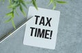 Tax Time concept on sticky note, pen on Gray background Royalty Free Stock Photo