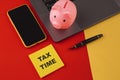 Tax time - notification of the need to file tax returns, tax form at accauntant workplace. Piggy bank in pink color with